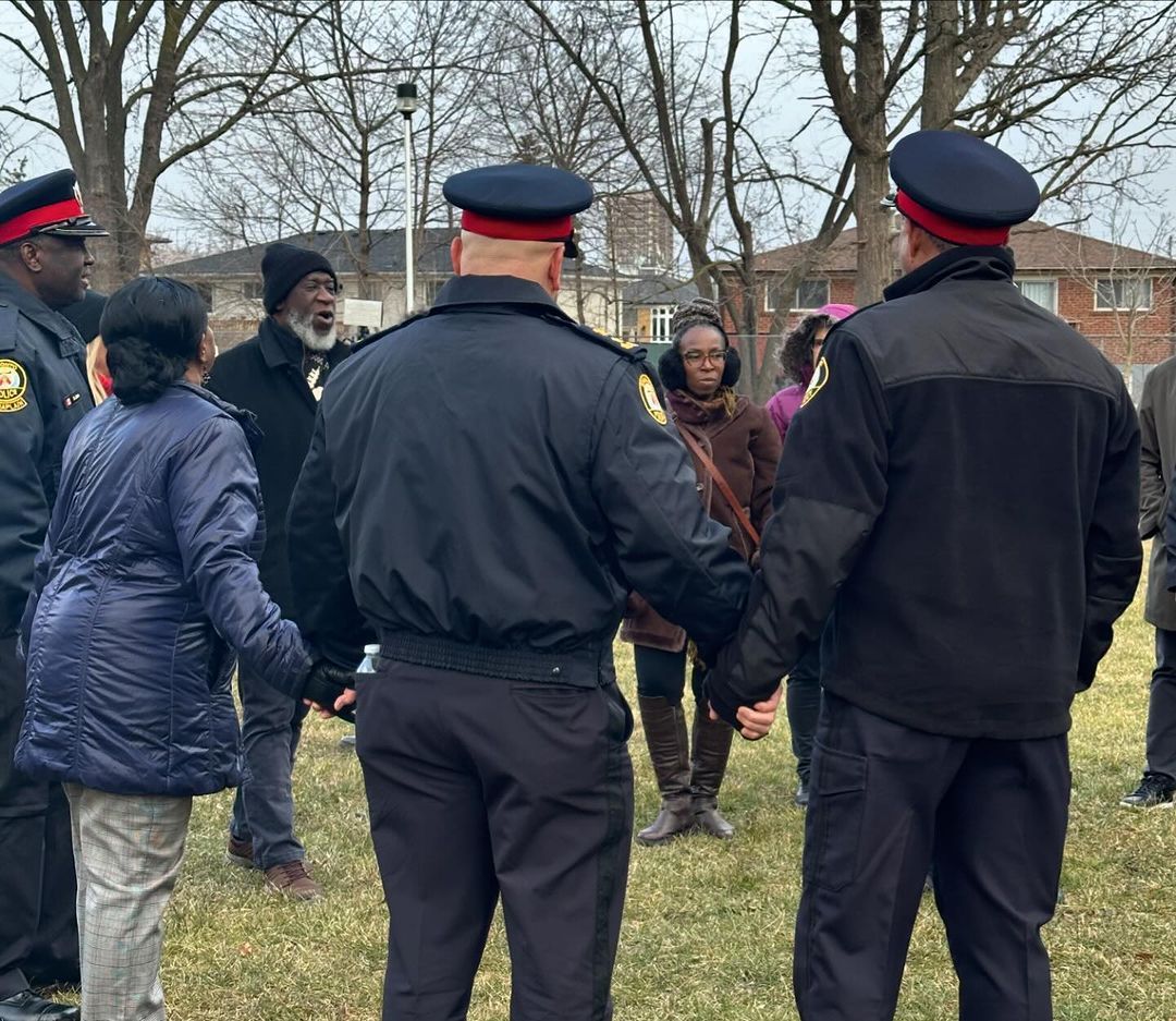 a group of police officers are standing in a field with people