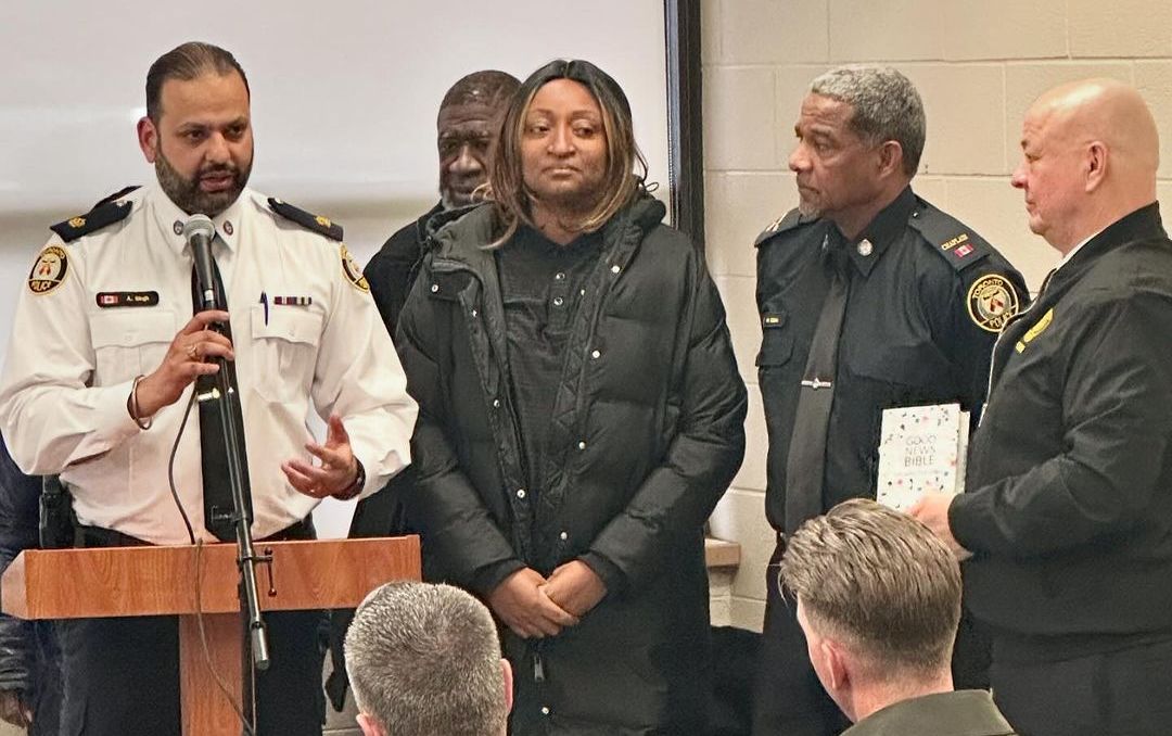 a group of police officers are standing around a podium giving a presentation