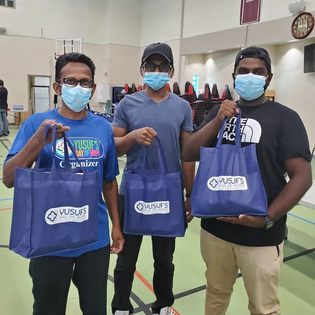 Three volunteers holding food bags