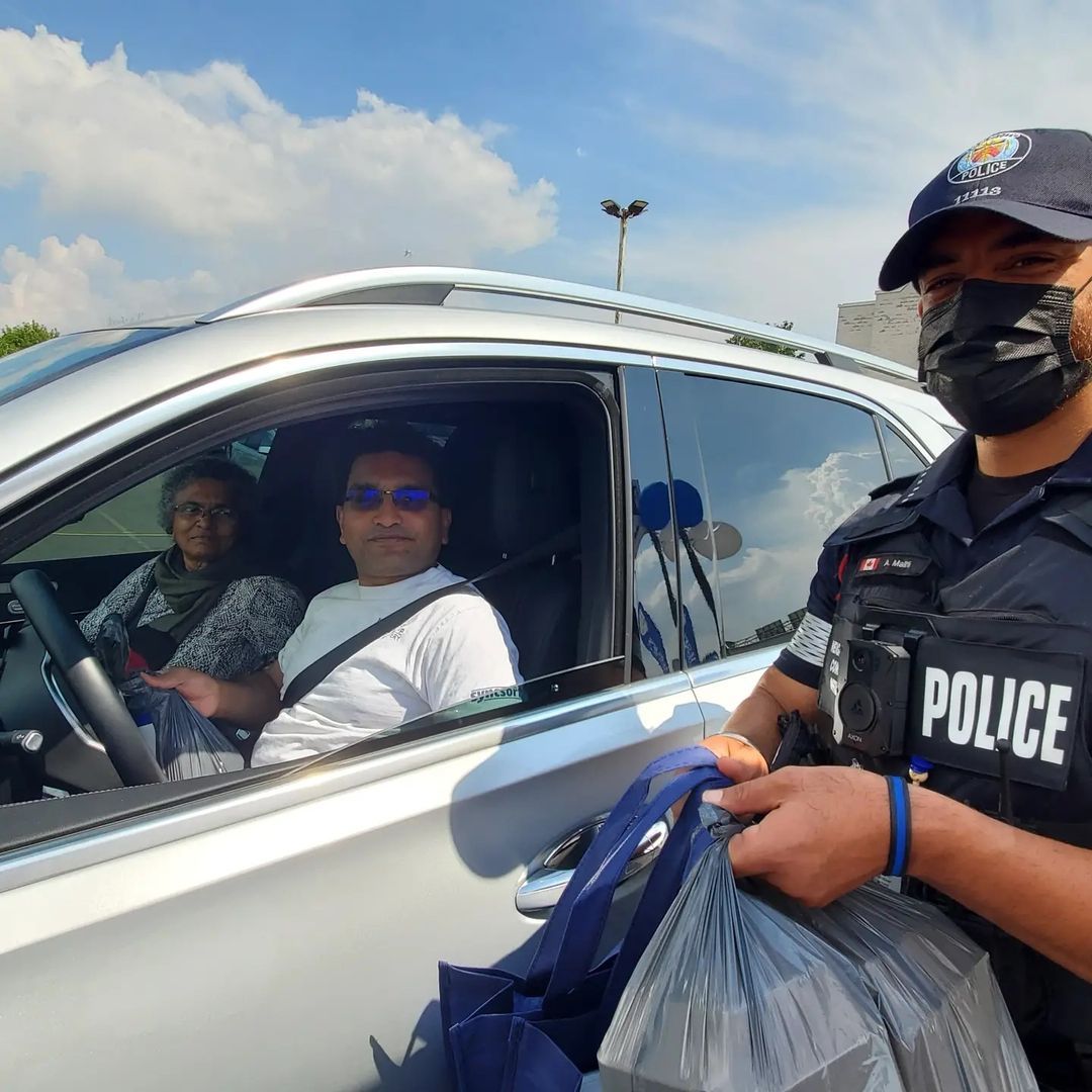 Officer giving food by a car