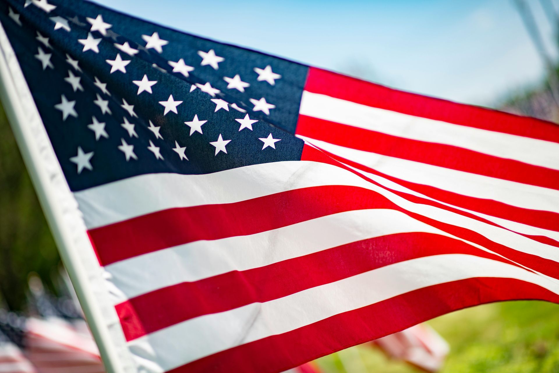 American flag waving against a blue sky