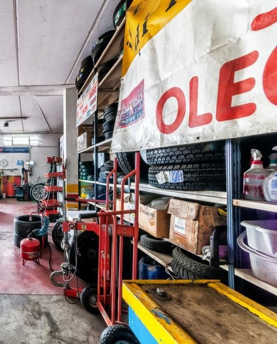 Due pneumatici neri per auto con cerchi in lega lucidi, uno dei quali mostra una pinza freno rossa, su sfondo bianco.