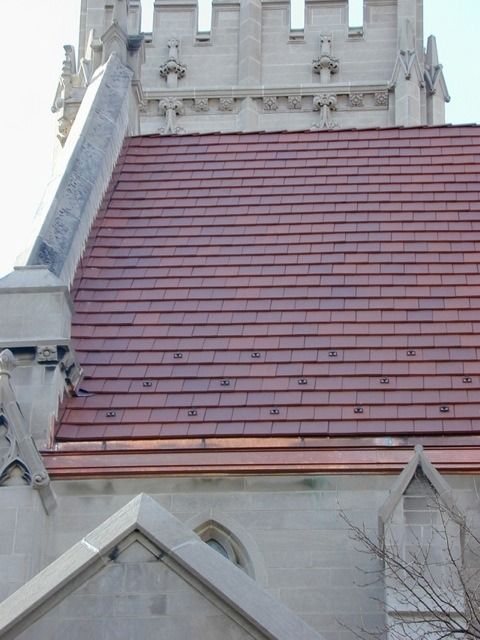 Red-tiled church roof and stone tower against the sky