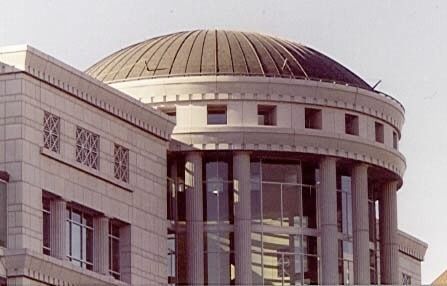 Domed building with columns and brick facade, seen from below.