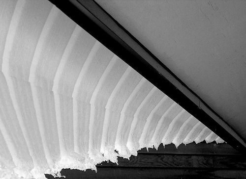 Black-and-white view of a curved staircase with repeating steps and a diagonal railing