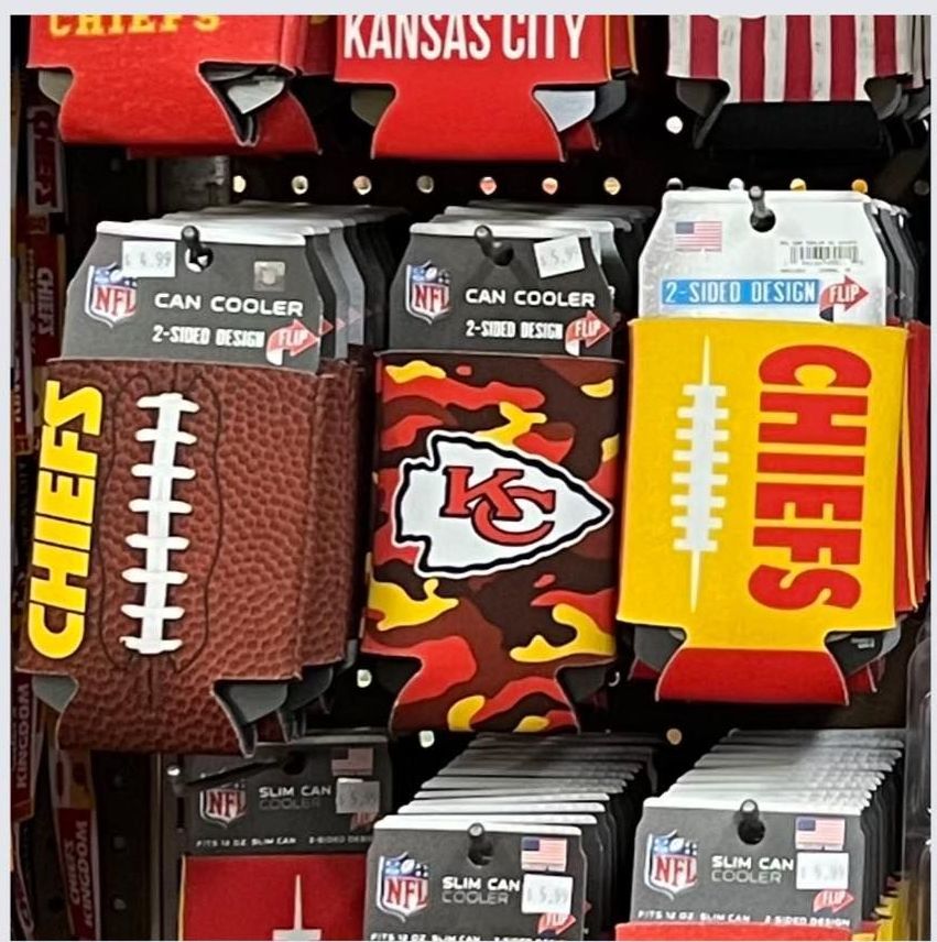 A retail display of Kansas City Chiefs NFL-themed can coolers in various designs, including football, camo, and yellow.