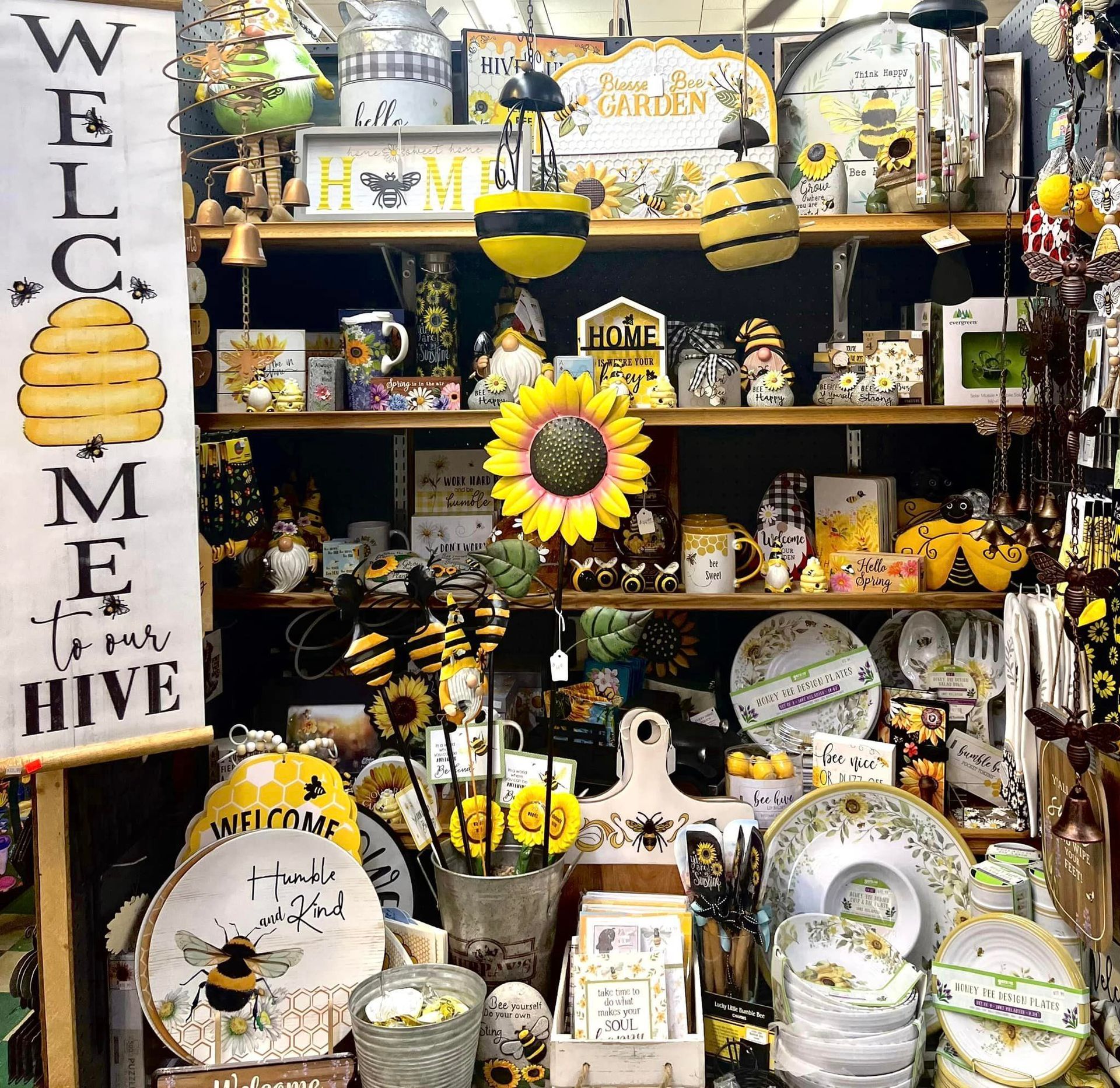 Shelves filled with sunflower and honeybee-themed home decor, including signs, plates, and ornamental bee figures.