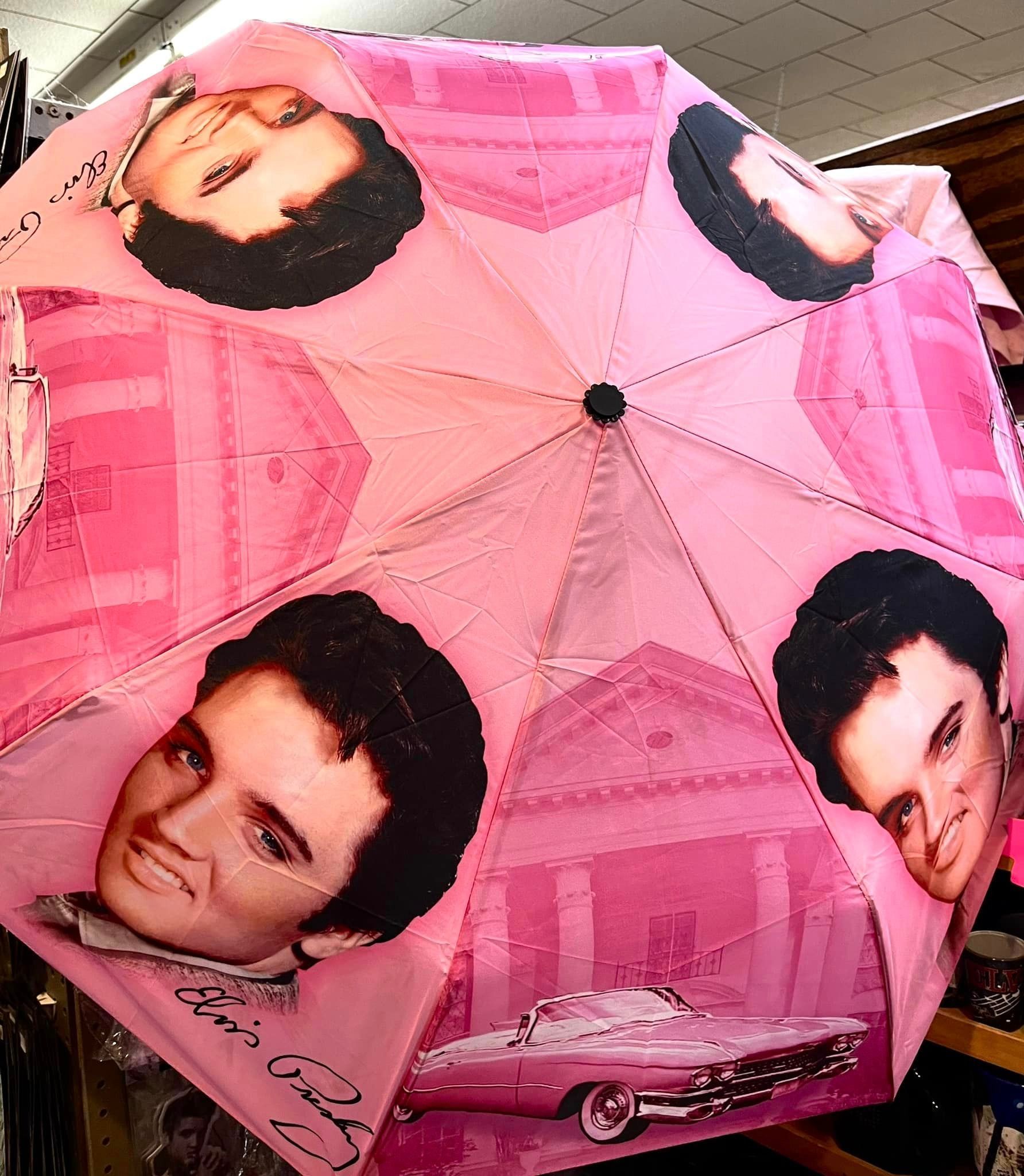 A pink umbrella featuring recurring images of Elvis Presley, his signature, and a vintage car.