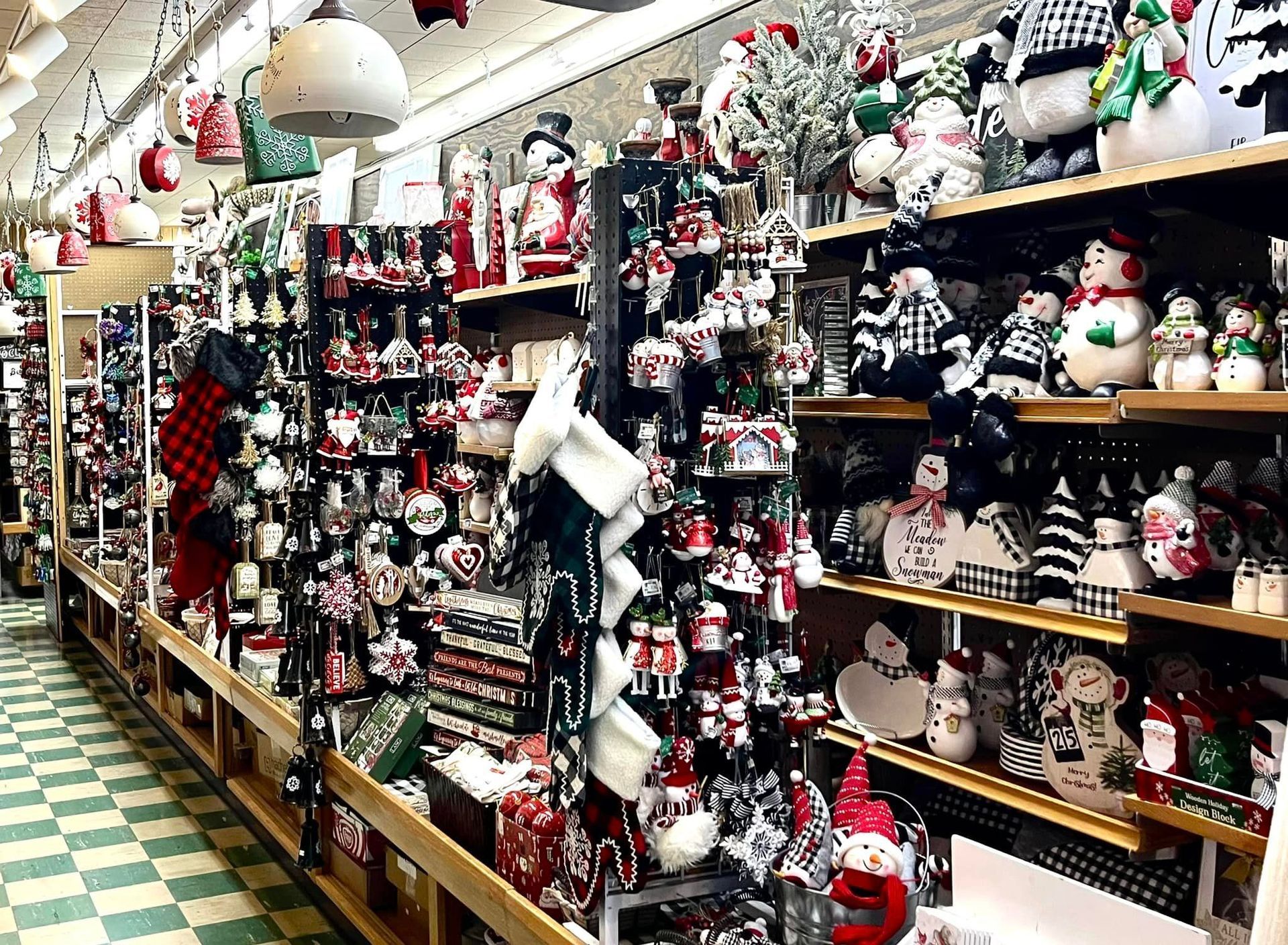 A store aisle filled with diverse Christmas ornaments, festive figurines, and holiday decorations on wooden shelving.