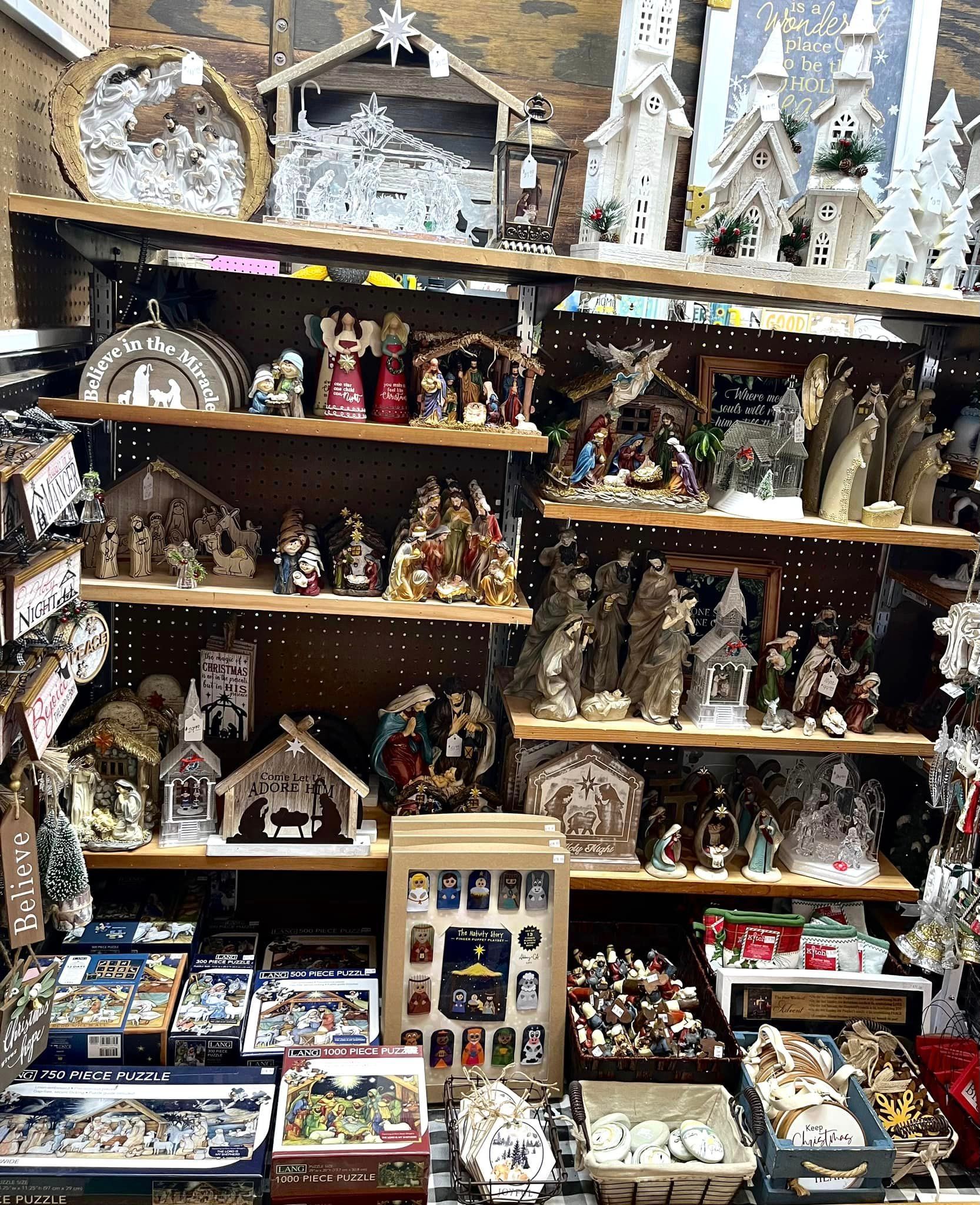 Shelves filled with various Christmas nativity scene sets, decorative figurines, and holiday-themed boxed puzzles.