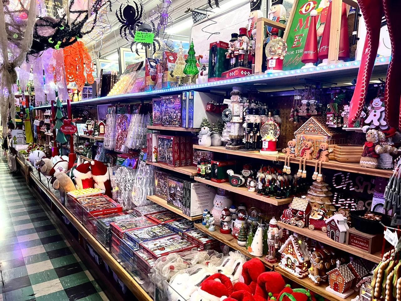 A store aisle filled with Christmas decorations, including nutcrackers, gingerbread houses, and ornaments on shelves.