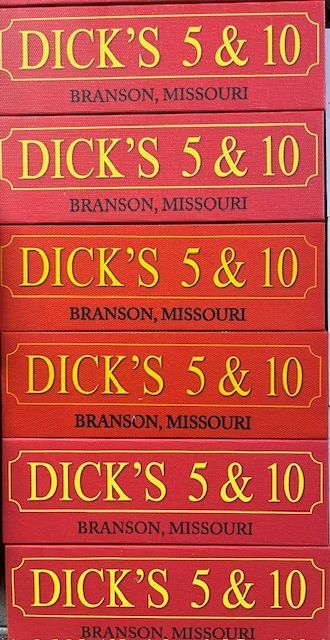 A vertical stack of six identical rectangular red signs with gold text reading