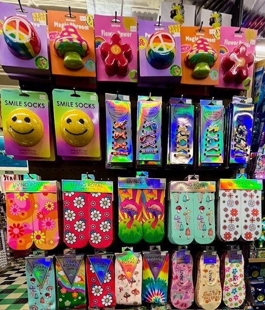 Retail display wall featuring packaged novelty socks, various patterned ankle socks, and colorful decorative ornaments.