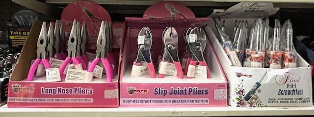 Store shelves display three boxes of tools: long-nose pliers, slip-joint pliers, and screwdrivers with pink handles.