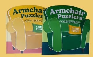 Two Armchair Puzzlers activity books featuring large print word searches and crosswords, displayed as illustrated chairs.