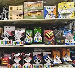 Shelves filled with various Rubik's Cubes, puzzle games, and brain teasers in retail packaging.