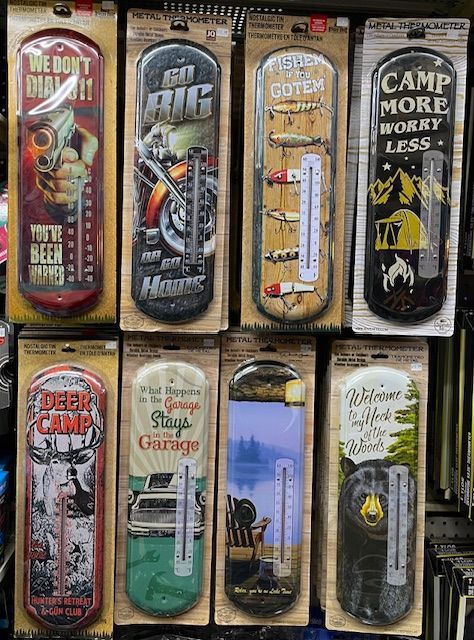 A wall display of eight vertical novelty thermometers featuring various themes like hunting, camping, fishing, and cars.