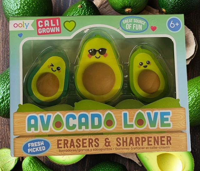 A packaging set of avocado-shaped erasers and a sharpener, featuring three cute, cartoon-faced avocado figures.