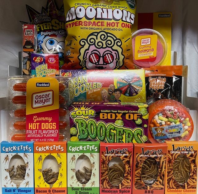 A collection of novelty candies and snacks, including gummy hot dogs, Bean Boozled, and edible cricket and mealworm snacks.