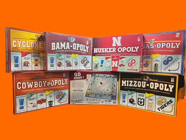 Seven board game boxes themed after different college sports teams arranged against an orange background.