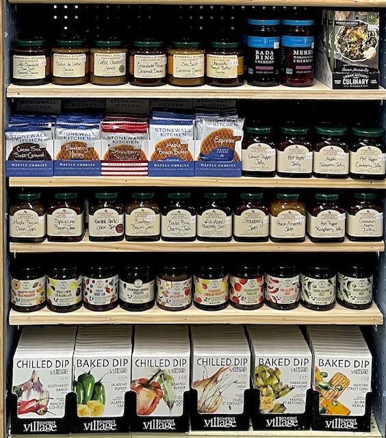 Store shelves filled with jars of spreads, packaged crackers, and boxes of chilled or baked dip mixes.