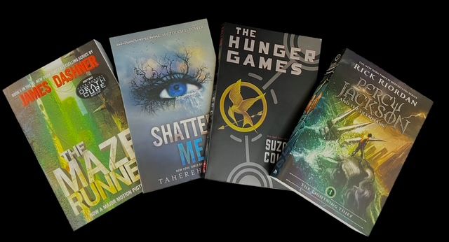 Four popular young adult book covers: The Maze Runner, Shatter Me, The Hunger Games, and a Percy Jackson book.
