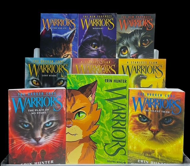 A display of nine Warriors book covers by Erin Hunter, featuring close-up illustrations of cats in various colors.