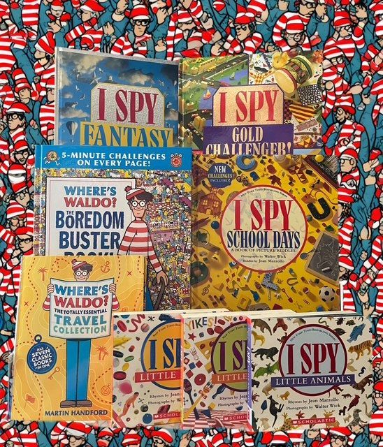 A collection of various Where’s Waldo and I Spy books stacked against a backdrop patterned with Waldo figures.