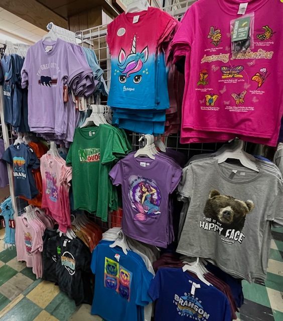 A store display filled with a variety of colorful graphic t-shirts hanging on racks.