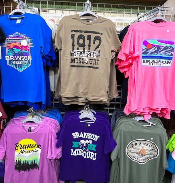 A store rack displaying various t-shirts with