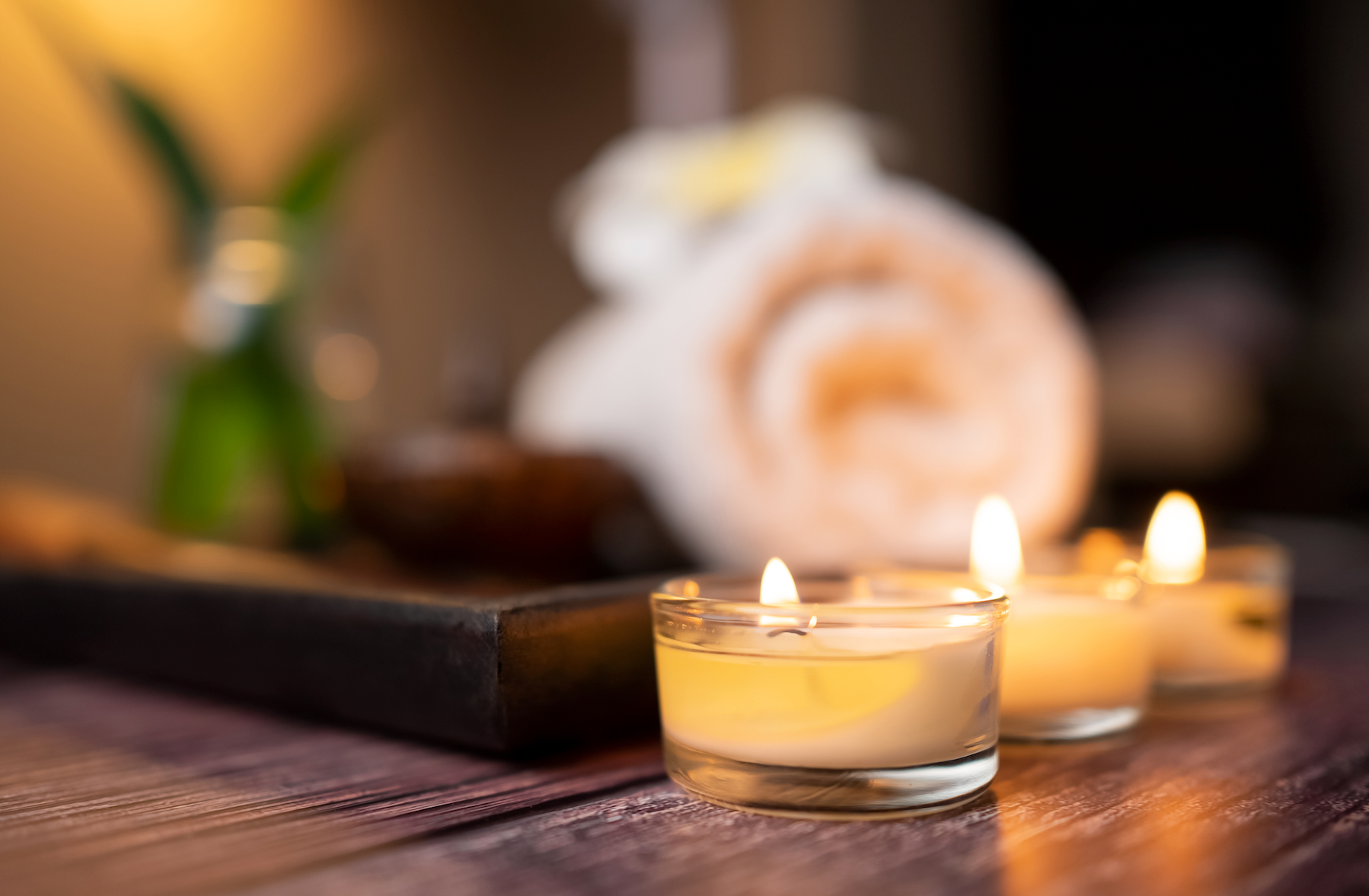 There are candles and towels on the table in the background.