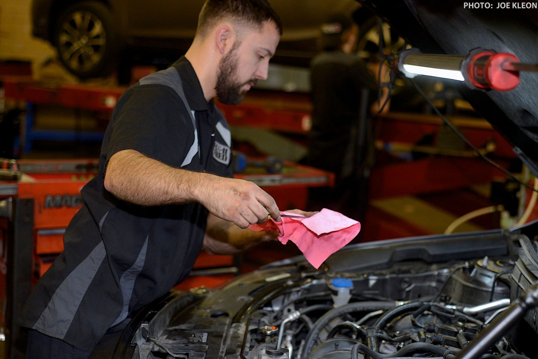 Team Discussing Suspension Repairs Under Lifted Car | Fix-it With Fred