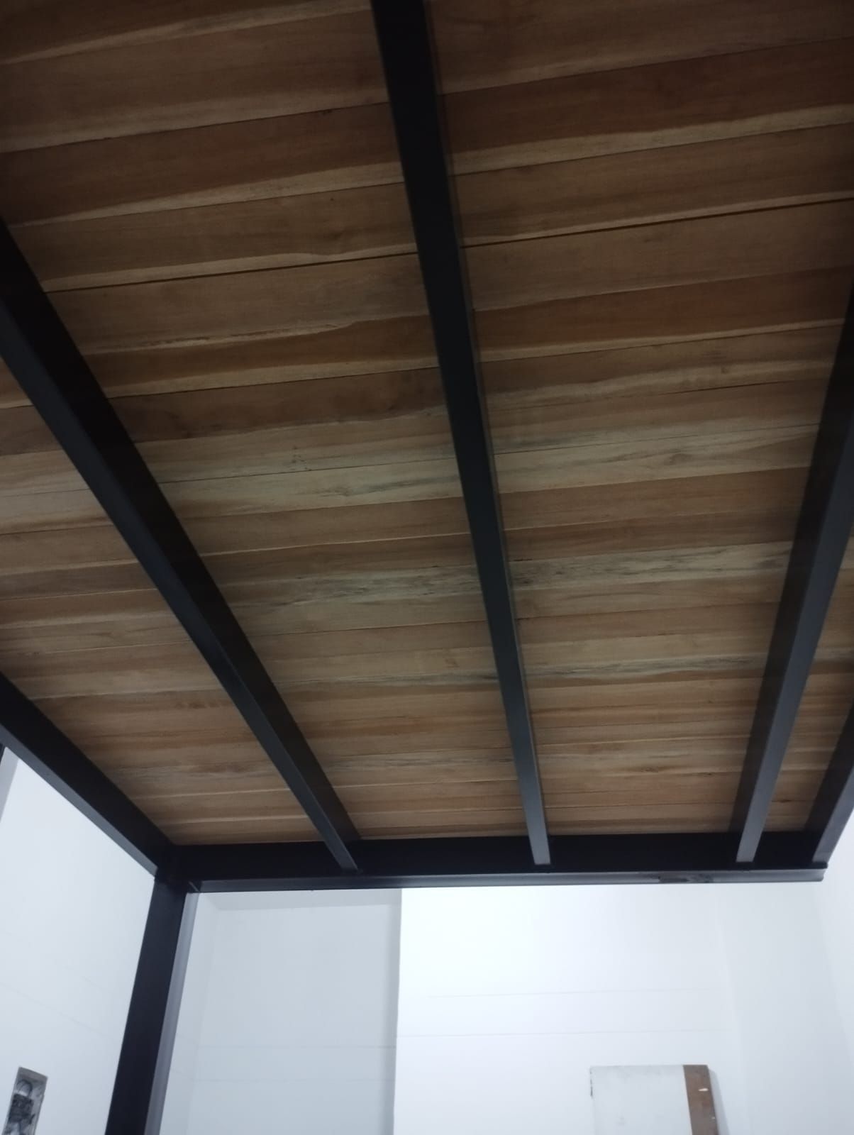Techo de madera con vigas oscuras.
