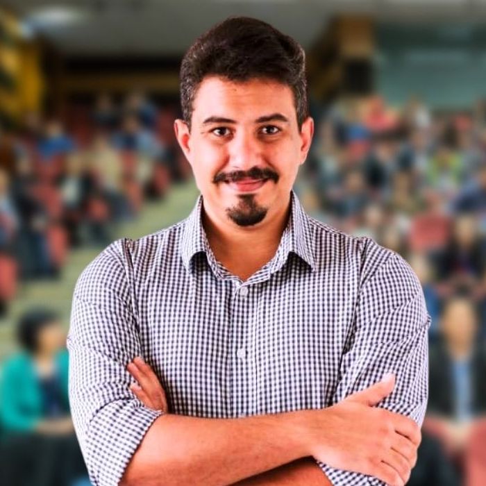 Um homem com os braços cruzados na frente de uma multidão