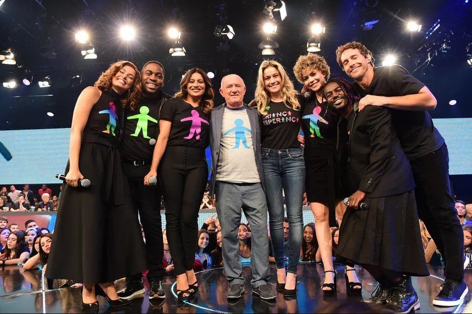 Um grupo de pessoas posa para uma foto em um palco.