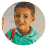 Um menino com uma mochila está sorrindo em círculo.