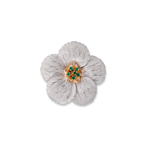Un fiore bianco con pietre verdi al centro su uno sfondo bianco