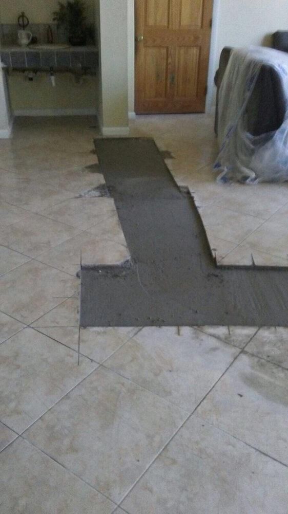 Indoor room with tiled floor and a dark taped path leading to a wooden door