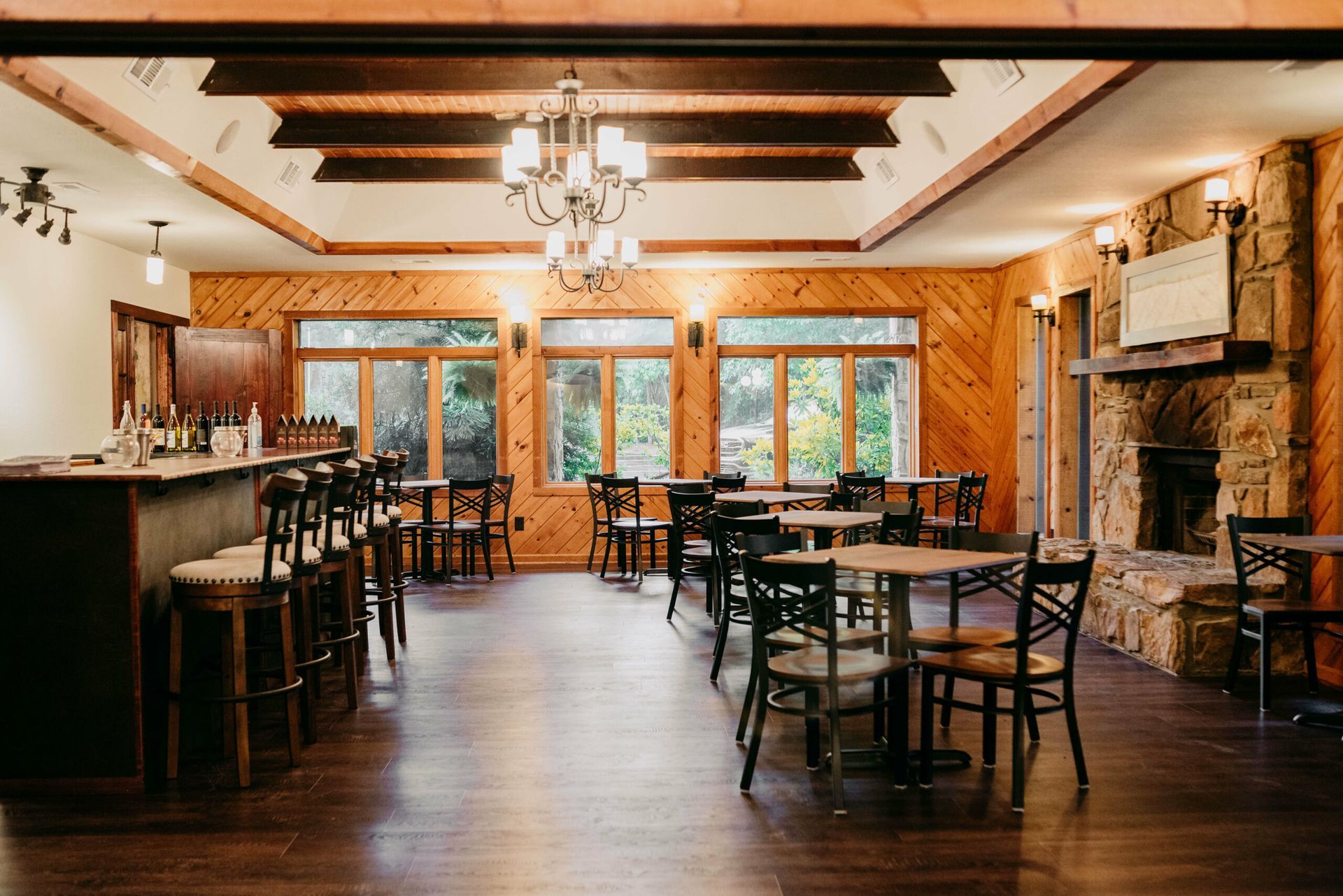 A large room with tables and chairs and a fireplace.