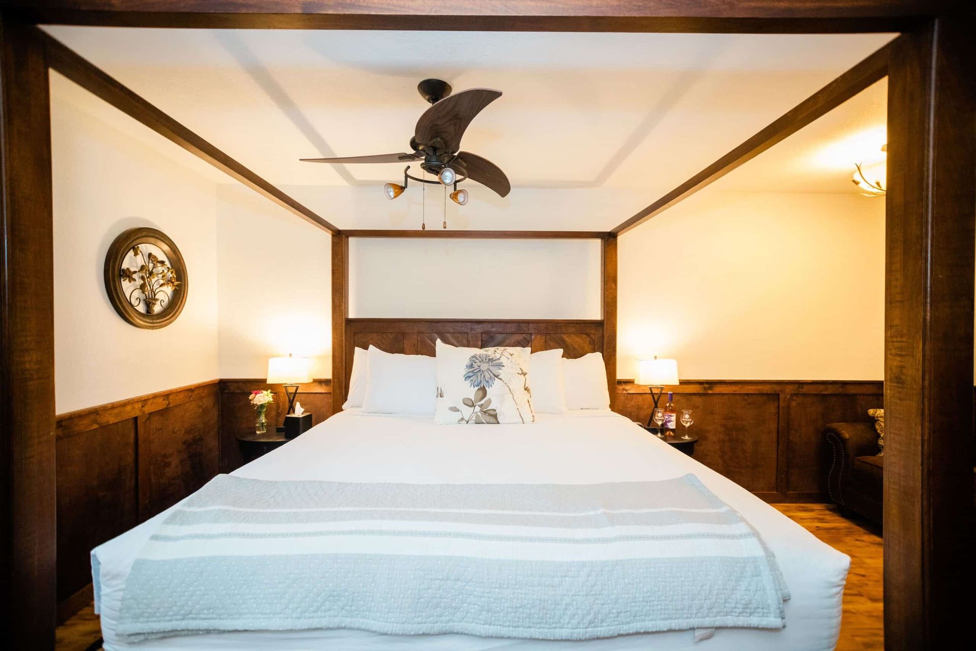 A bedroom with a king size bed and a ceiling fan.