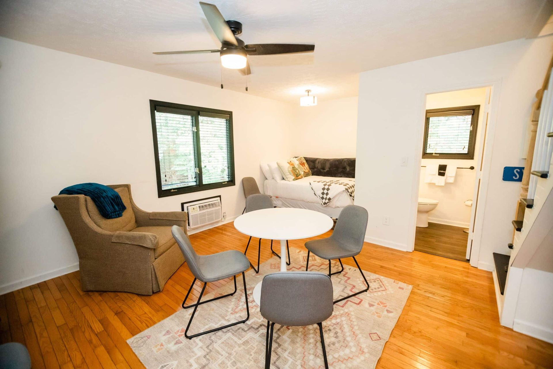 A living room with a table and chairs and a ceiling fan.