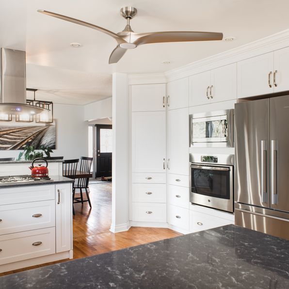 A kitchen with stainless steel appliances and a ceiling fan
