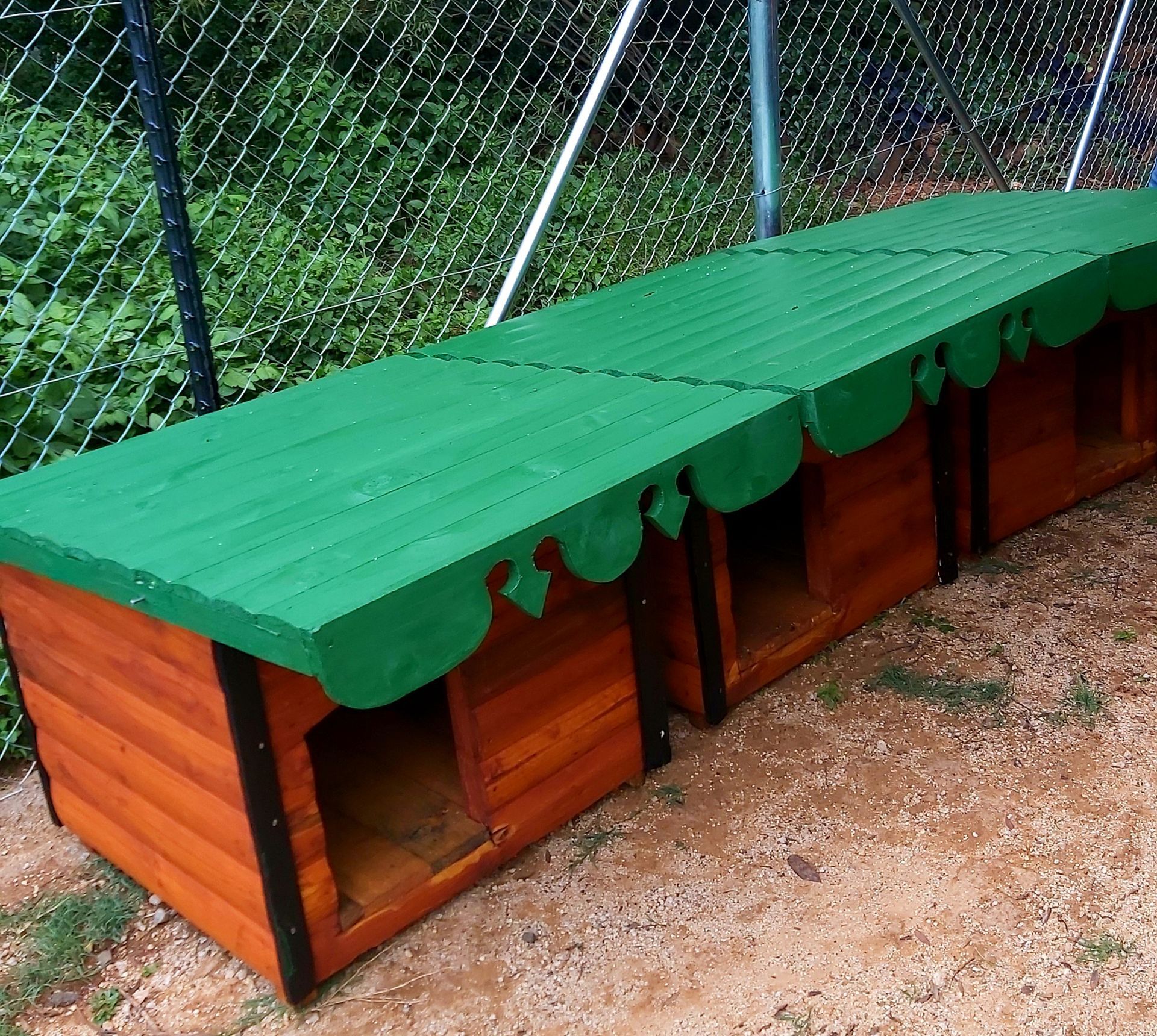 A wooden dog house with a green roof