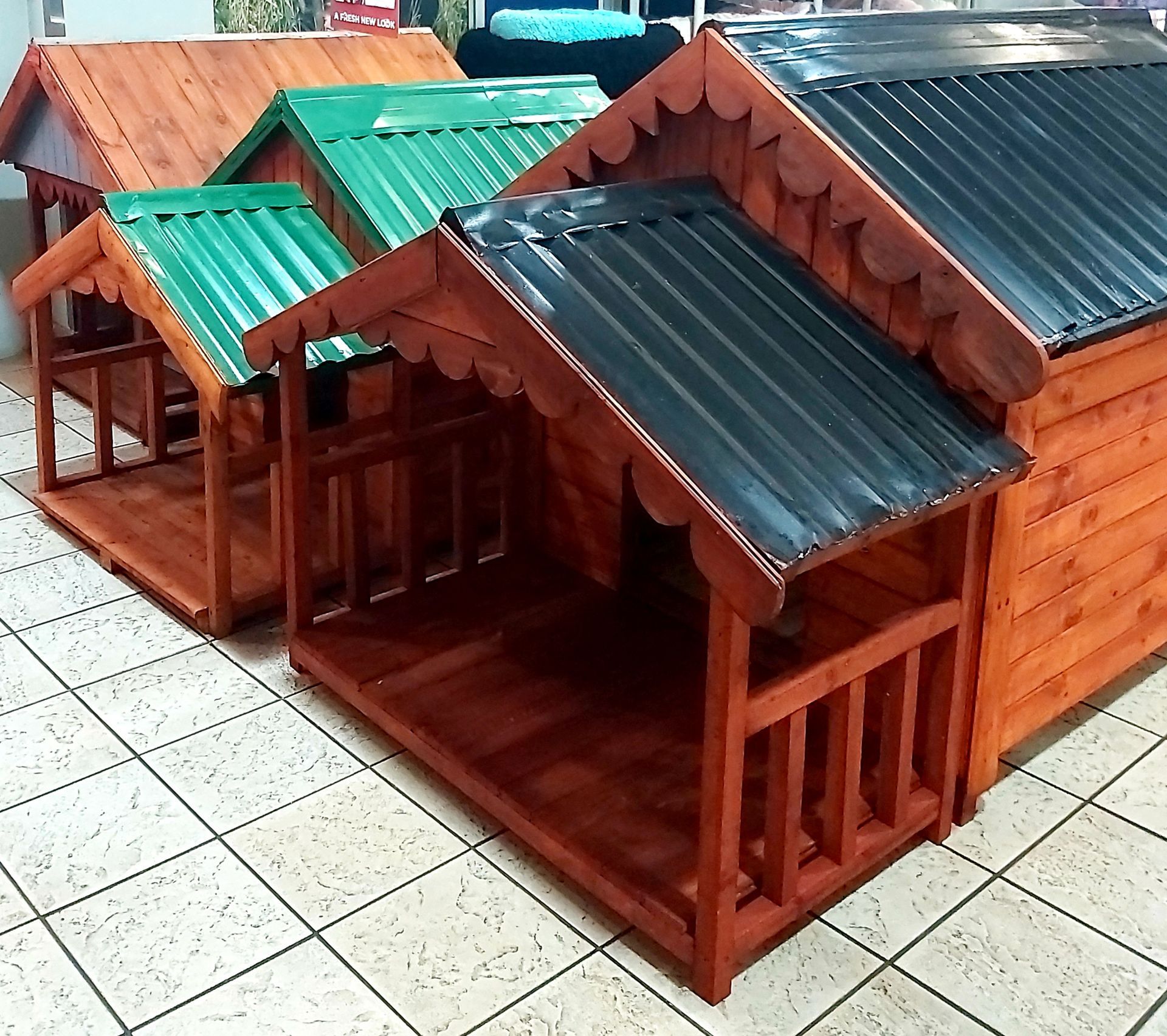 A row of wooden dog houses with metal roofs