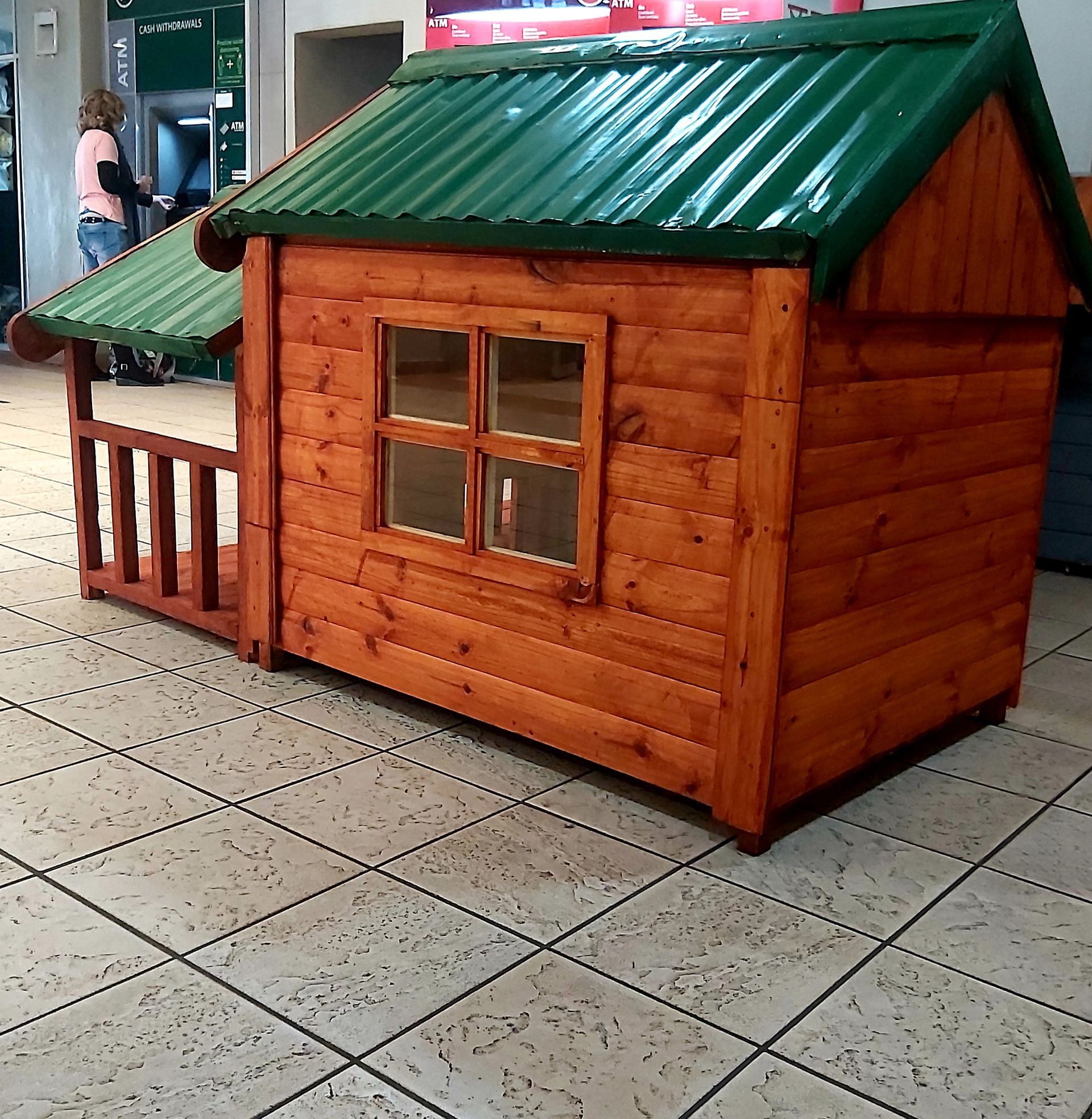 A small wooden house with a green roof