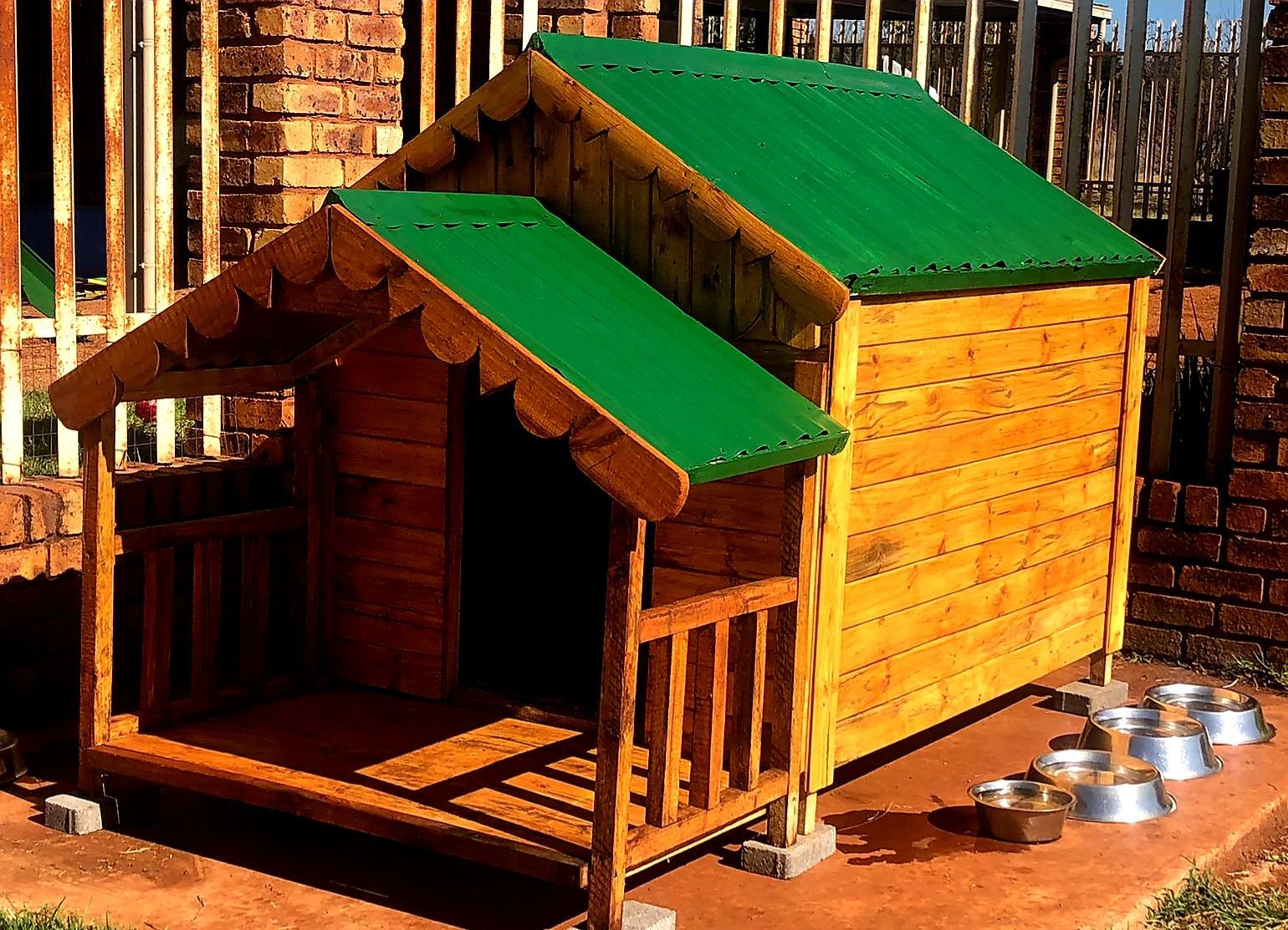 A wooden dog house with a green roof available at Pets and the City in Pretoria East.