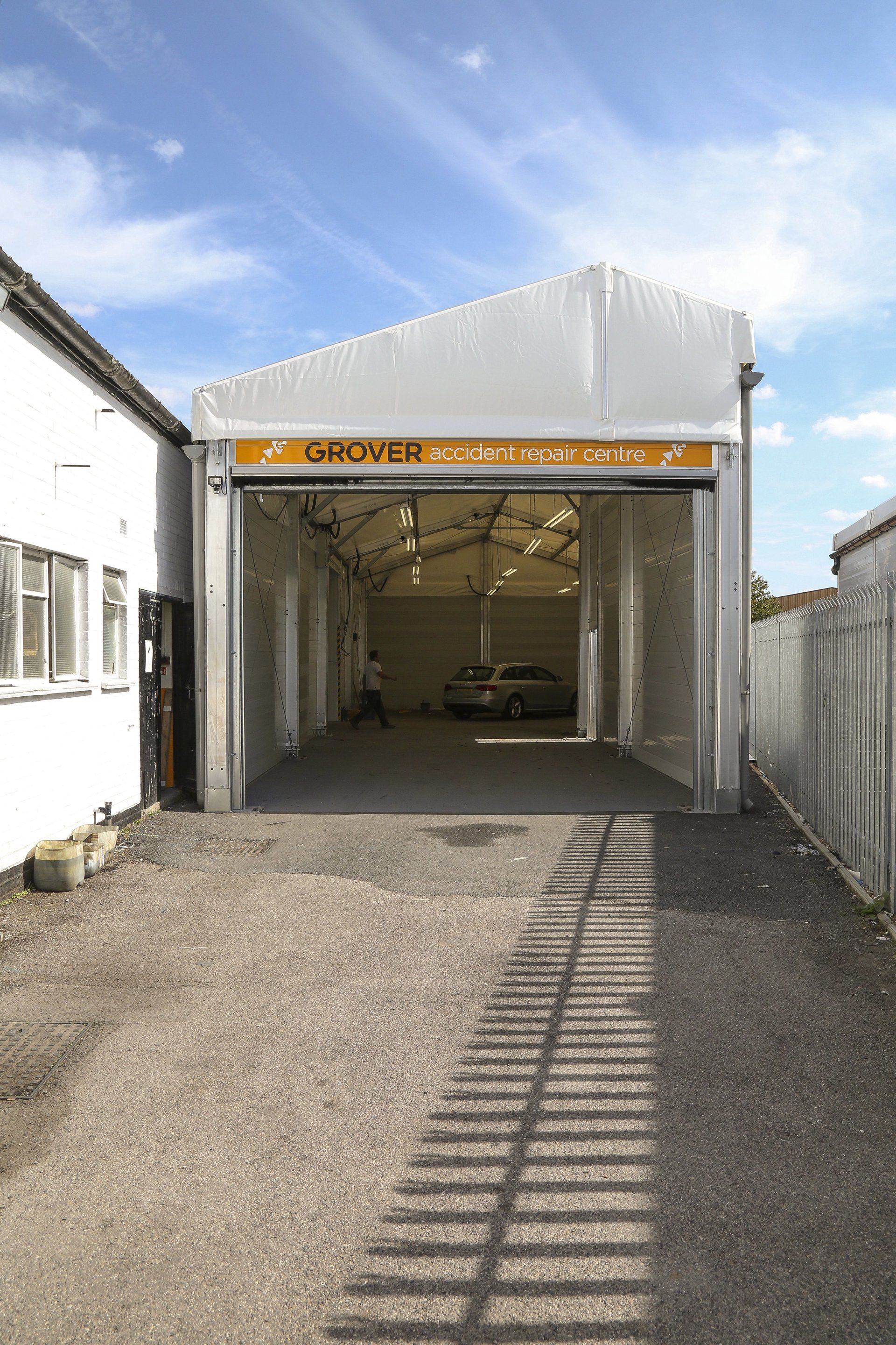 A car is parked in a garage with the door open.