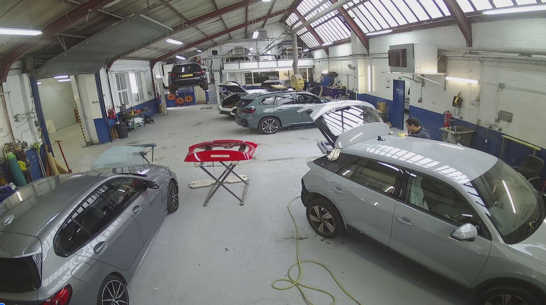 A row of cars are parked in a garage.