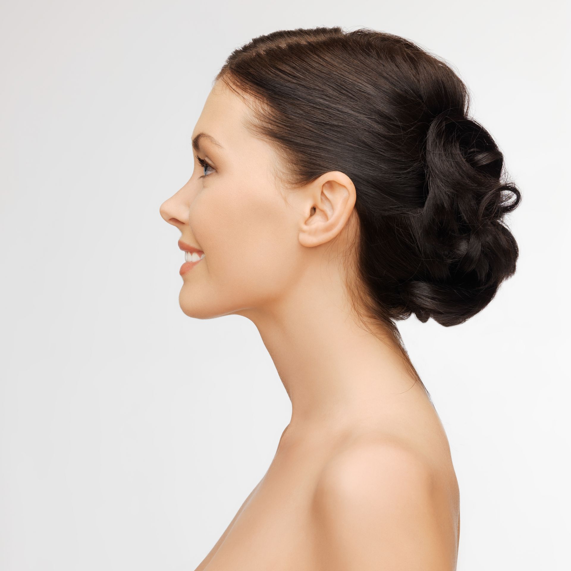 A woman without a shirt has her hair in a bun
