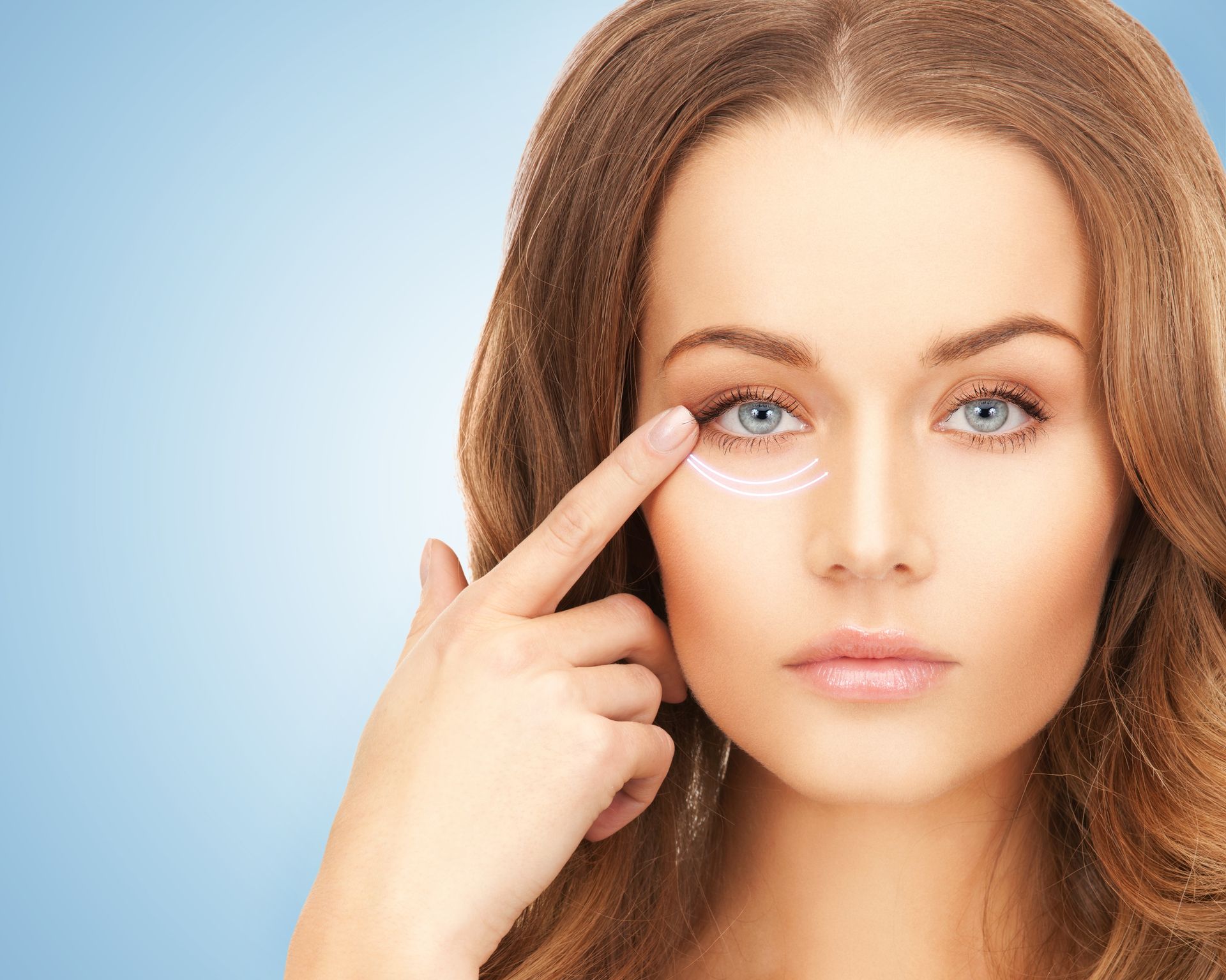 Woman touching under-eye area, highlighting a wrinkle or eye cream on a light blue background